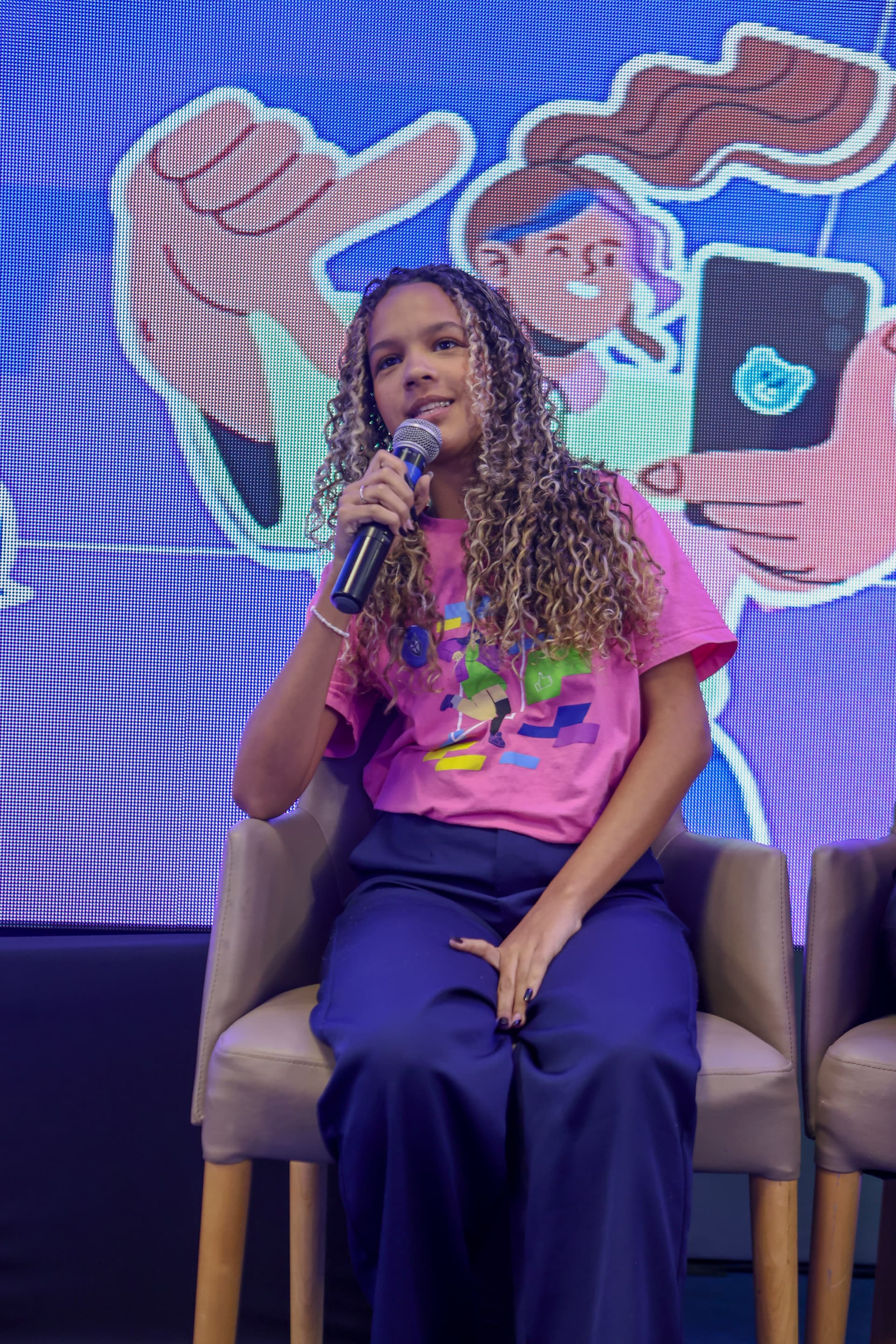 Nathanny Cordeiro falando ao microfone em um evento.